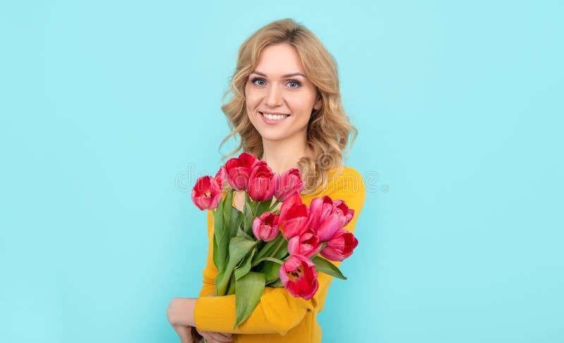 glad young woman with spring tulip flowers on blue background royalty free stock images