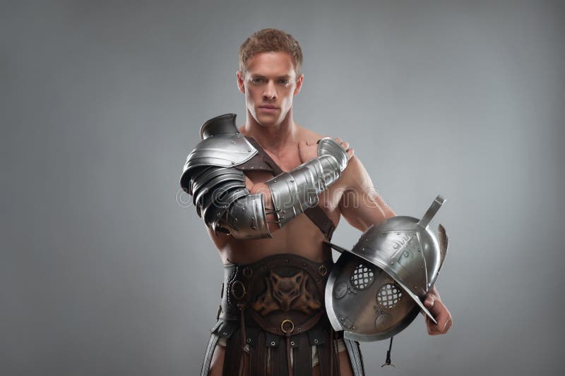 Gladiator In Pantser Het Stellen Met Helm Over Grijs Stock Foto -  Afbeelding bestaande uit agressie, kaukasisch: 42994294