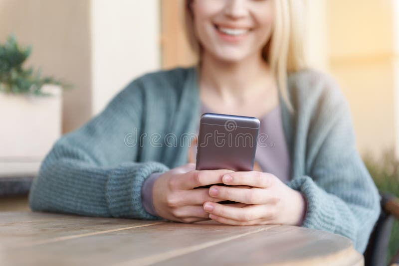 Gladlynt blond flicka som masserar på mobiltelefonen arkivfoto Gladlynt blond flicka som masserar på mobiltelefonen arkivfoto