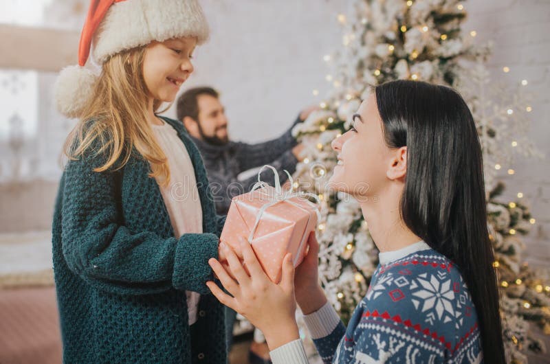 Gladlynt mamma för glad jul och för lyckliga ferier och hennes gullig dotterflicka som utbyter gåvor Förälder och litet barn arkivfoto