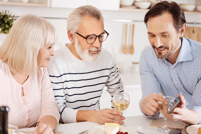 Gladlynt mogen son som hemma tycker om familjmatställen royaltyfri fotografi Gladlynt mogen son som hemma tycker om familjmatställen royaltyfri fotografi