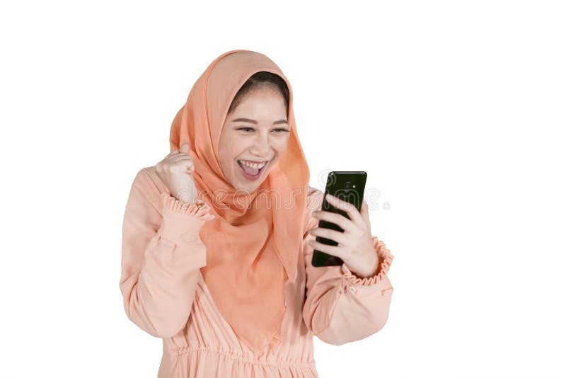 Gladlynt muslimsk kvinna som använder en telefon på studio arkivfoton Gladlynt muslimsk kvinna som använder en telefon på studio arkivfoton