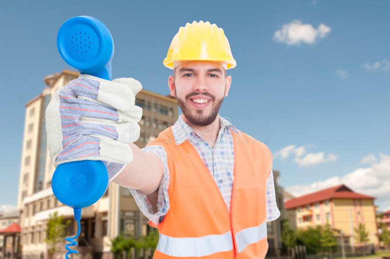 Gladlynt ung arkitekt som ger dig telefonmottagaren royaltyfri bild Gladlynt ung arkitekt som ger dig telefonmottagaren royaltyfri bild