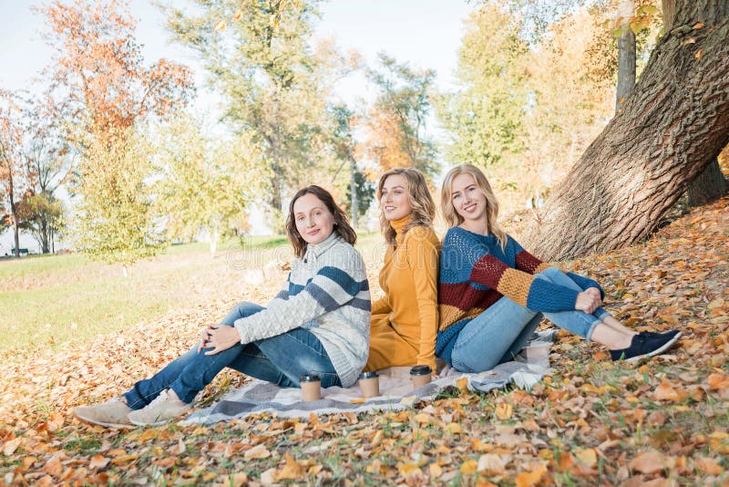 Gladlynta attraktiva tre bästa vän för unga kvinnor som har picknicken och gyckel tillsammans utanför arkivfoto Gladlynta attraktiva tre bästa vän för unga kvinnor som har picknicken och gyckel tillsammans utanför arkivfoto