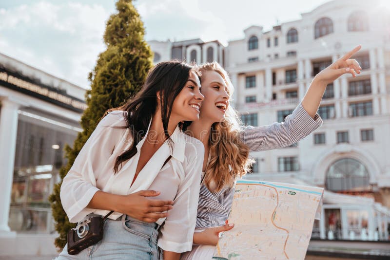 Glamorous Female Tourists Exploring City Together Carefree Blonde Girl With Map Laughing With