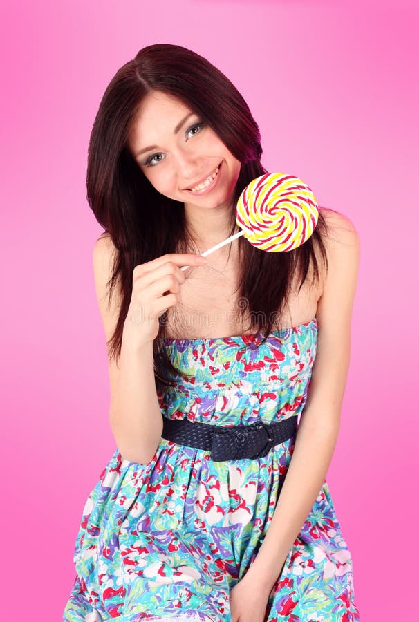 Glamorous girl wearing colorful dress with lollipo