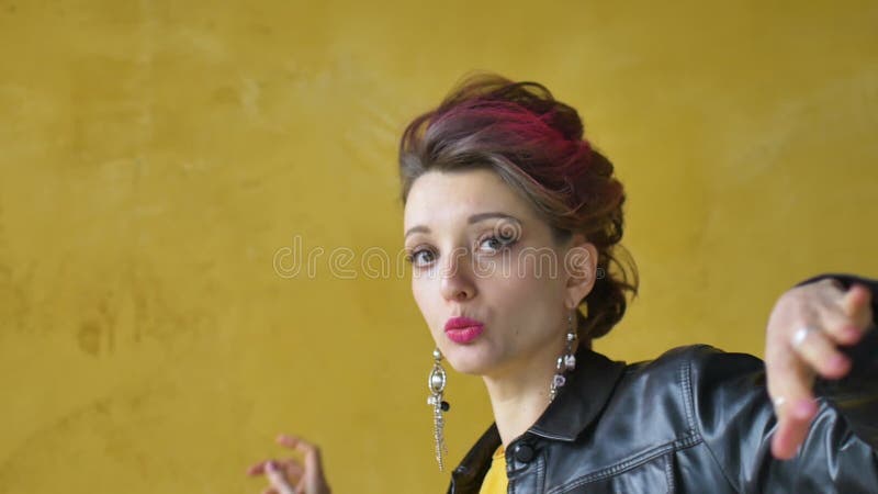 Glamorous lady in punk rock style party clothes with dark pink hair in casual dress, black leather jacket, and long