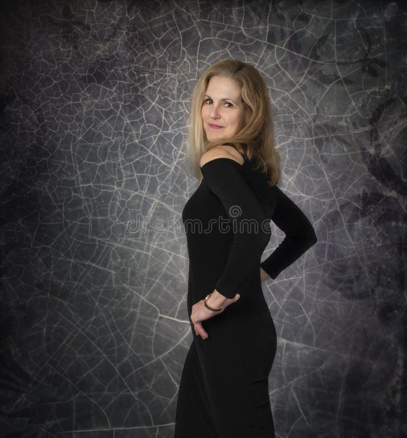 Glamorous Mature Woman in Black Dress Against Textured Background Stock Image image