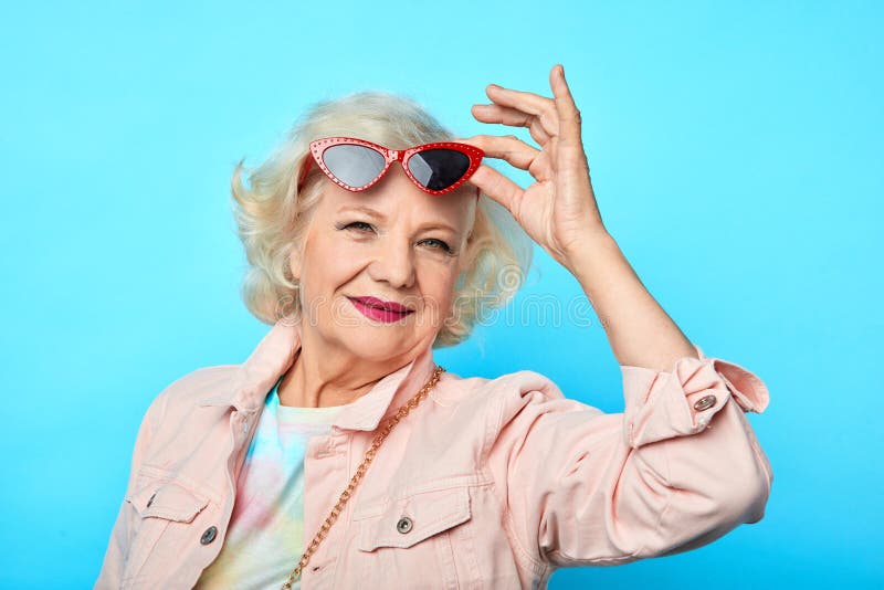Glamour het oude vrouw opstijgen, die op zonnebril zetten royalty-vrije stock fotografie Glamour het oude vrouw opstijgen, die op zonnebril zetten royalty-vrije stock fotografie