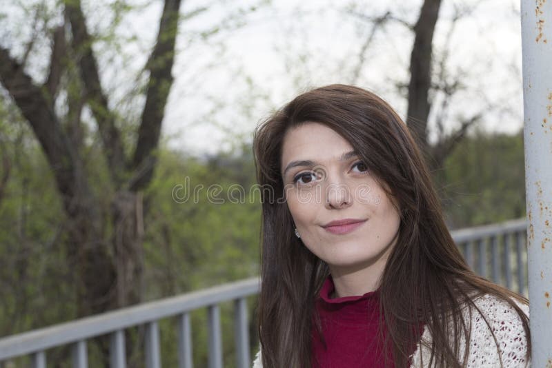 Charming young woman in white cardigan. Shooting has been in the spring city within the Roses Valley Park. Charming young woman in white cardigan. Shooting has been in the spring city within the Roses Valley Park