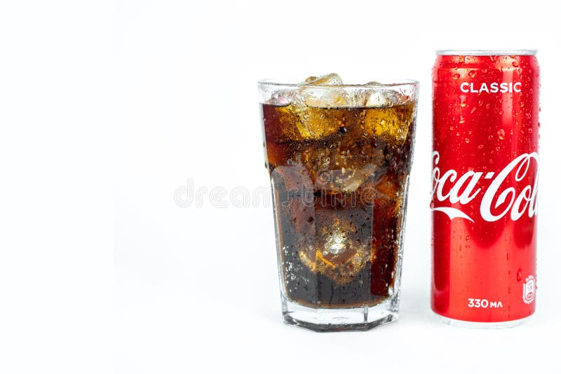 Glas av kalluppfräschande coca cola soda med ismetallburk av coca cola klassisk isolerad på vitt arkivfoto