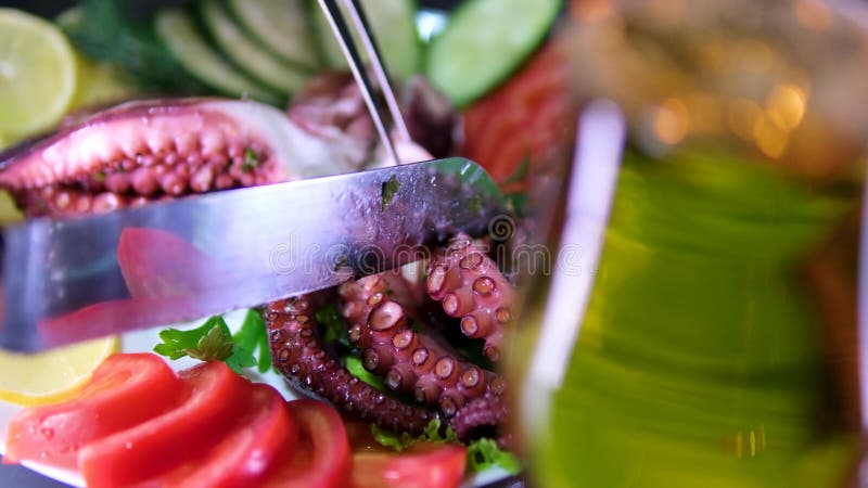 Glas Bierjungen Küchenchef schneidet Oktopus in einer modernen Küche. Der Mann bereitet zu Hause Essen zu.. gesunde Ernährung. stock footage