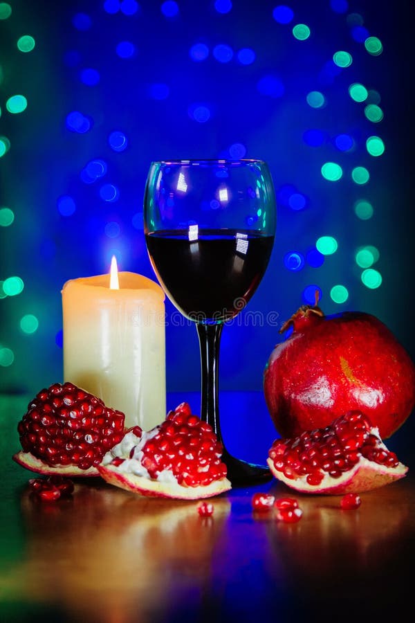 Glas des Rotweins, des reifen Granatapfels und der brennenden Kerze lizenzfreie stockfotografie Glas des Rotweins, des reifen Granatapfels und der brennenden Kerze lizenzfreie stockfotografie