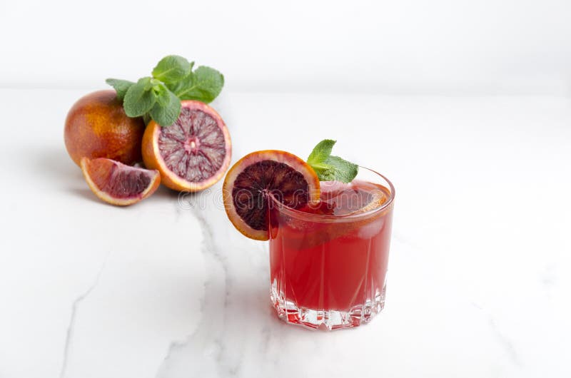 Glas frischen gemachten Blutorange Margarita mit Scheiben der Blutorange, der Eiswürfel und der Minze auf der weißen Marmortabell stockfotos Glas frischen gemachten Blutorange Margarita mit Scheiben der Blutorange, der Eiswürfel und der Minze auf der weißen Marmortabell stockfotos