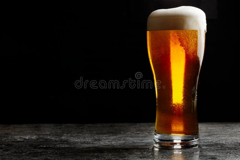 Glas helles Bier des kalten Handwerks auf dunklem Hintergrund lizenzfreie stockfotografie Glas helles Bier des kalten Handwerks auf dunklem Hintergrund lizenzfreie stockfotografie