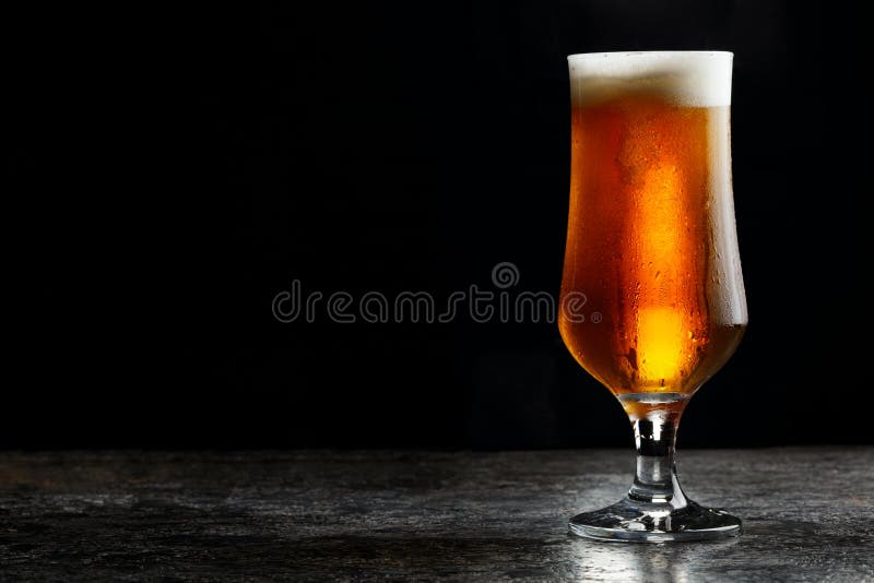 Glas koud ambacht licht bier op donkere achtergrond