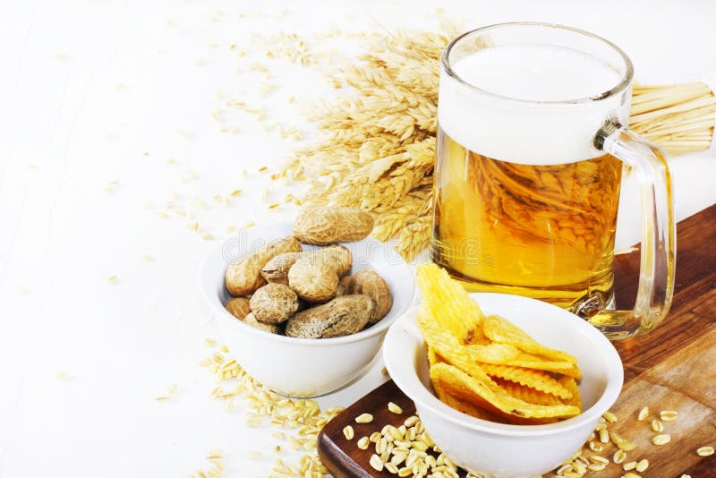 Glas koud bier met spaanders en pinda's op witte achtergrond royalty-vrije stock foto Glas koud bier met spaanders en pinda's op witte achtergrond royalty-vrije stock foto