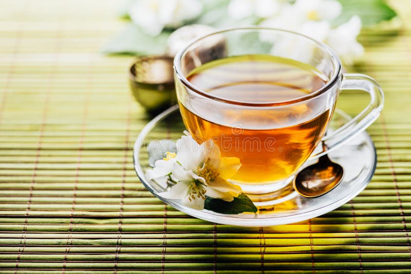 Glas warme kruidenthee op bamboe achtergrond-closeup Teacup met organische groene thee en verse jasmijnbloem op houten tafel royalty-vrije stock foto's Glas warme kruidenthee op bamboe achtergrond-closeup Teacup met organische groene thee en verse jasmijnbloem op houten tafel royalty-vrije stock foto's