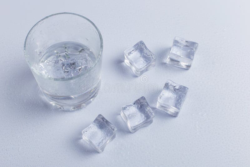 Glas Wasser mit Eis auf weißem Grund isoliert lizenzfreie stockfotos
