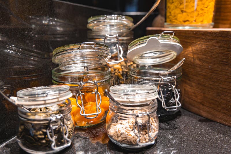Glasburkar med torkade varor på Glossy Black Countertop med lyxinställning royaltyfria bilder