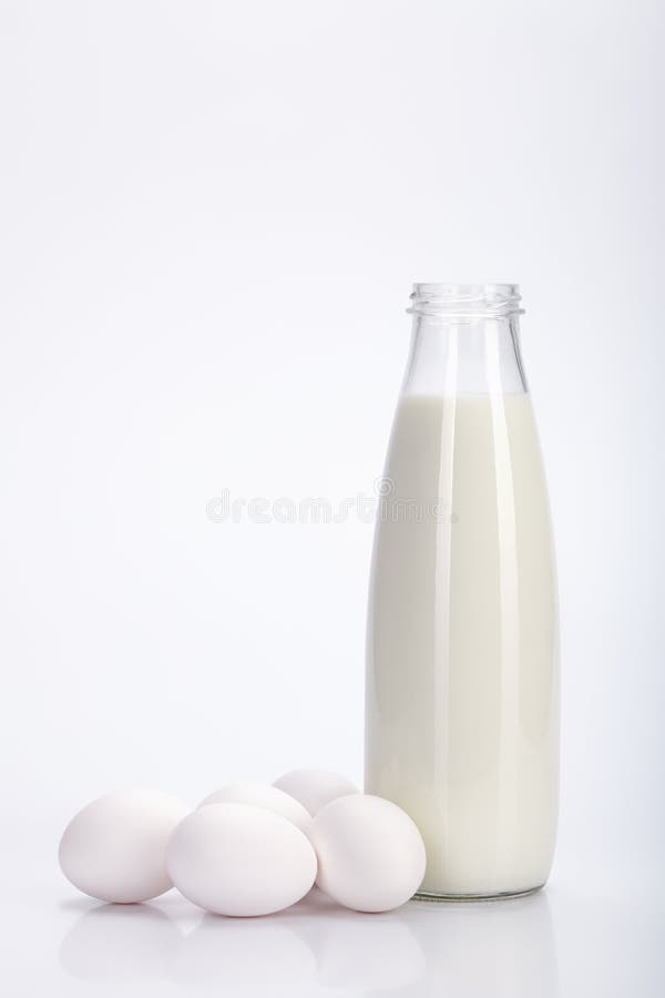 Glasflasche Milch und einige Eier Weißer Hintergrund stockbilder