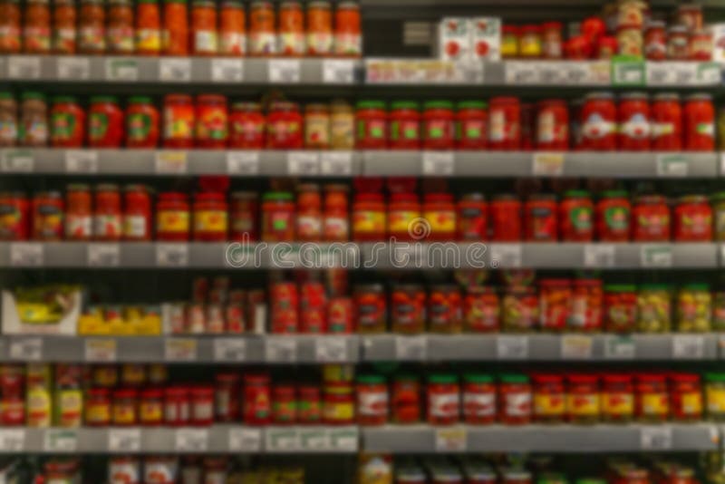Glasgefäße mit eingemachtem Gemüse auf Regalen in einem Supermarkt. ein großes Sortiment. verschwommen stockbilder
