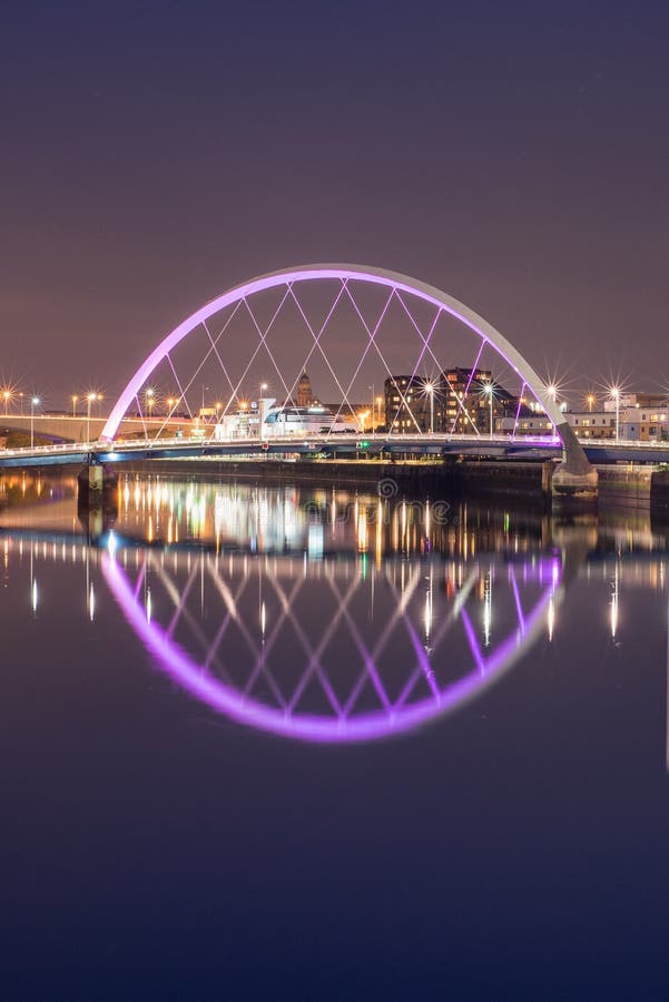 The Clyde Arc Lit Up in Violet and Surrounding Buildings, Reflected in