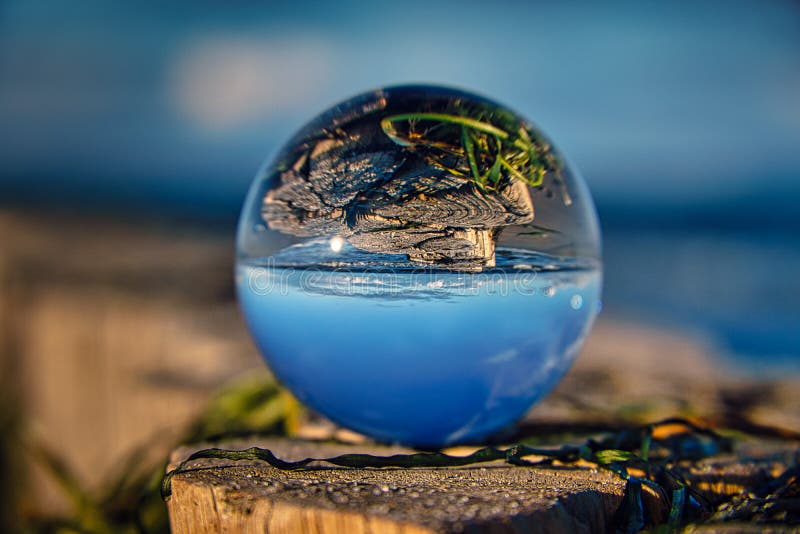 Glass Ball on Beach, Capturing the Landscape in the Glass Stock Image