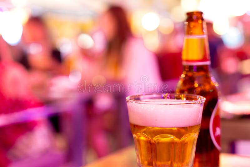 Glass of Beer with Bottle in Extremely Colorful Crazy Lighting. Stock