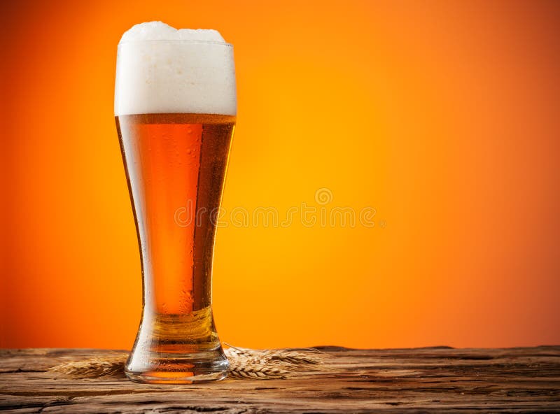 Glass of beer on wood with orange background royalty free stock photography Glass of beer on wood with orange background royalty free stock photography