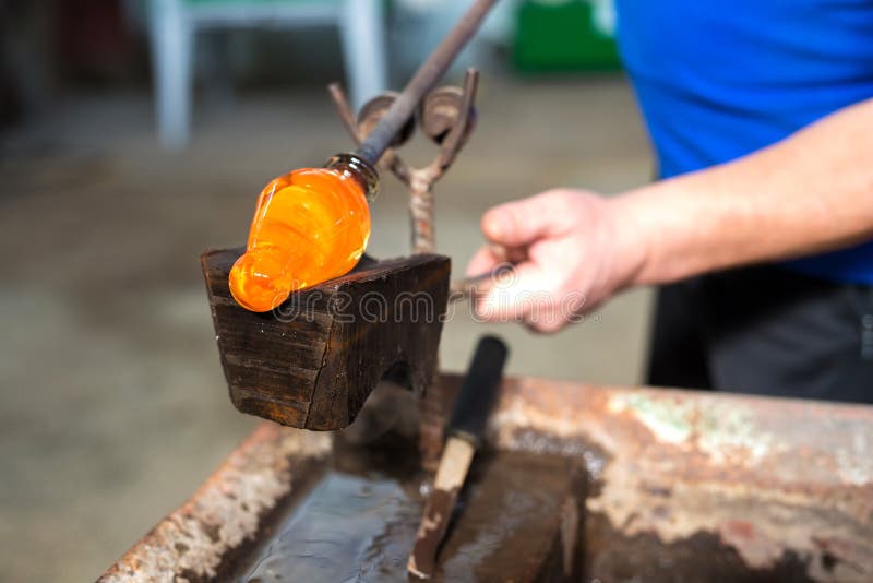 Glass Blowing the Hands of the Craftsman Working with Molten Glass