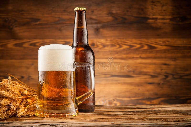 Glass and bottle of beer on wooden planks