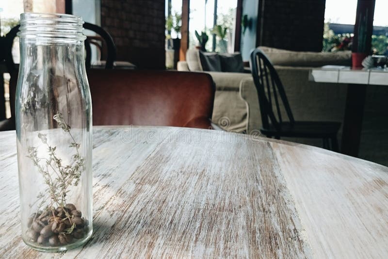 Glass Bottle of Coffee Bean and Dried Flower in Cafe Stock Image