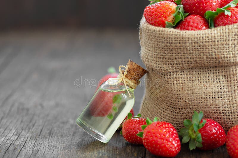 Bottle with Perfume from Strawberry Essential Oil on a Wooden Background.  Aromatherapy and Cosmetology Stock Photo - Image of bottle, floral:  189526894