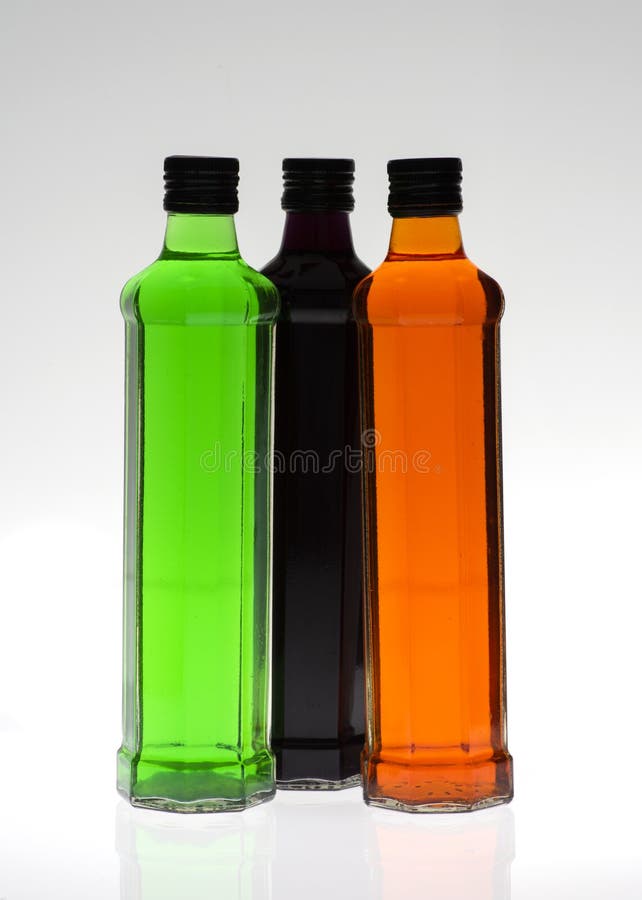 Glass Bottles Filled with Food Colouring on a White Background Stock