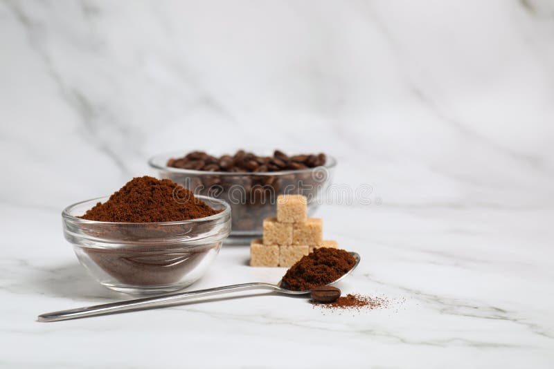 Glass Bowl and Spoon with Instant Coffee on White Marble Table. Space