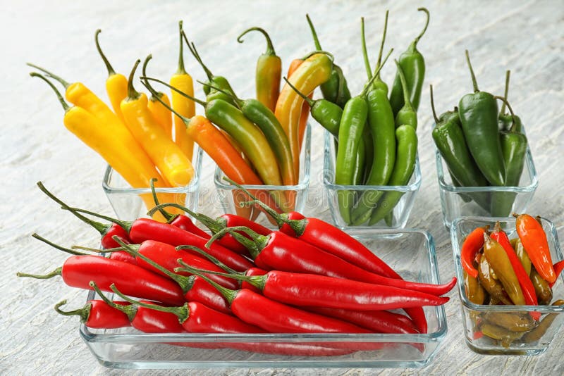 Glass bowls with fresh and canned chili peppers on light background royalty free stock photos Glass bowls with fresh and canned chili peppers on light background royalty free stock photos