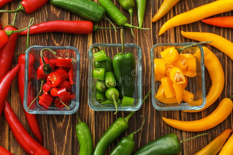 Glass bowls with fresh chili peppers on wooden background stock image Glass bowls with fresh chili peppers on wooden background stock image