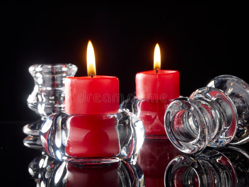Glass Candlesticks with Lit Red Candles Stand on Black Glass Stock