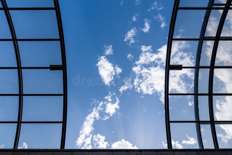 Glass ceiling with black grids. Abstract black stripes texture background, against the blue sky with clouds. royalty free stock image Glass ceiling with black grids. Abstract black stripes texture background, against the blue sky with clouds. royalty free stock image