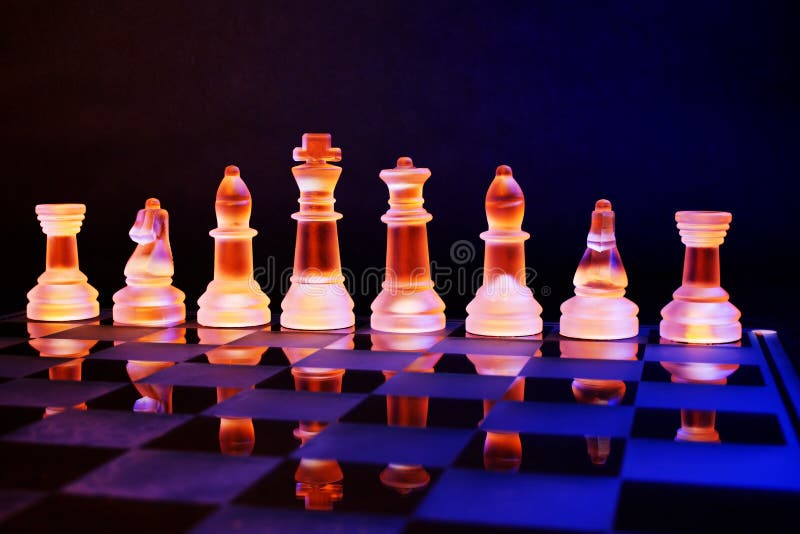 Glass chess on a chessboard lit by blue and orange light