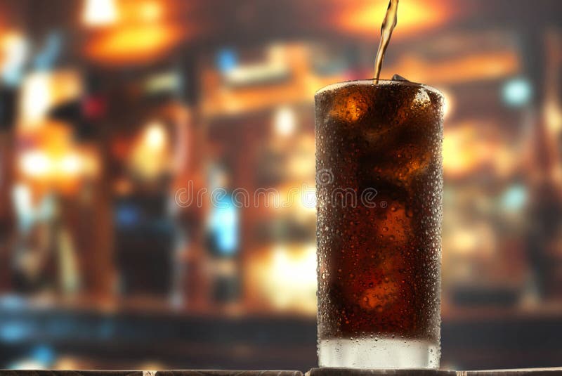 Glass of cold cola on a bar counter.