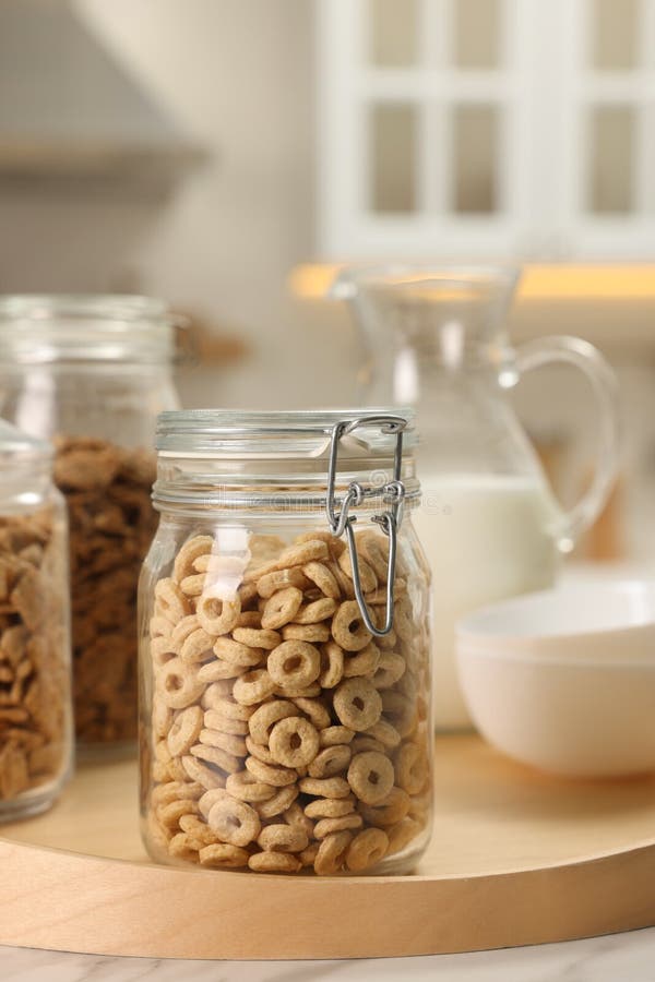 Glass Containers with Different Breakfast Cereals on White Marble Table