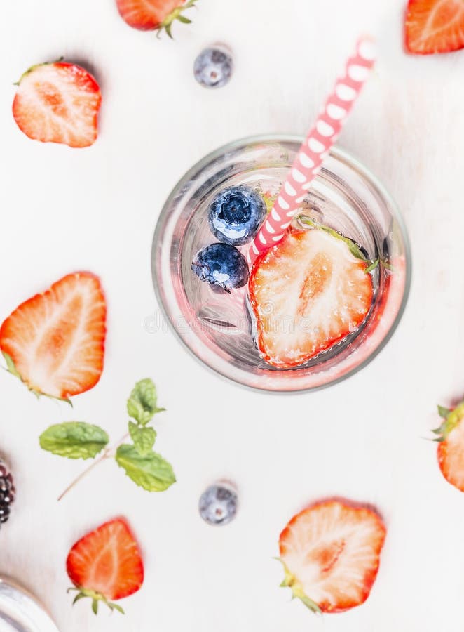 Glass of Detox drink with infused water , fresh berries , ice cubes and mint leaves