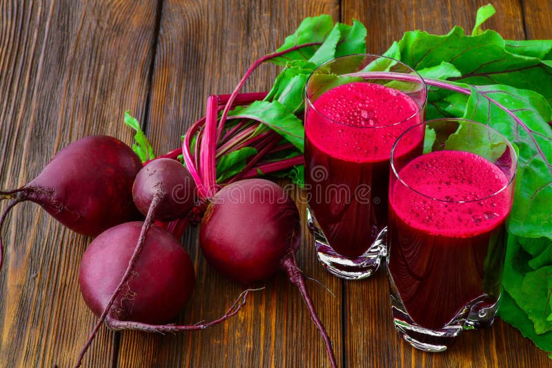 Glass of fresh beetroot juice with bets on wooden