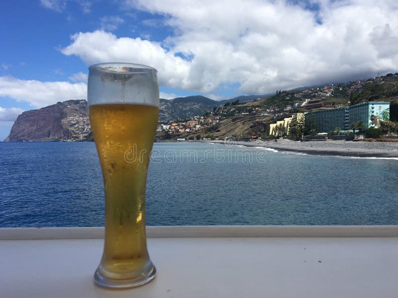 A glass of frosty ice cold beer against the ocean background royalty free stock image A glass of frosty ice cold beer against the ocean background royalty free stock image