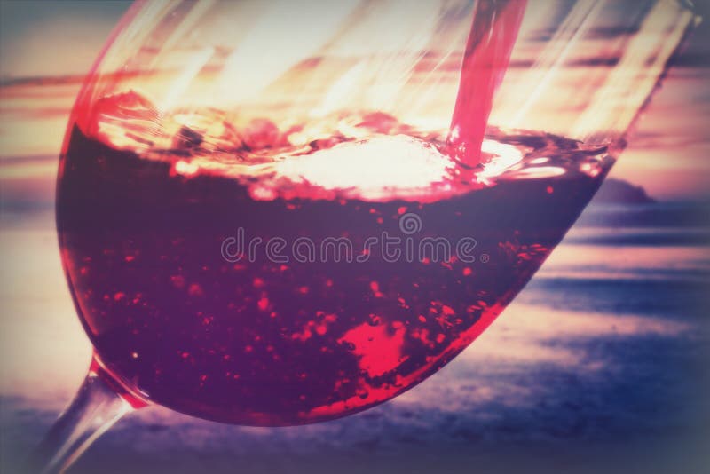 Glass of full bodied red wine being poured stock image