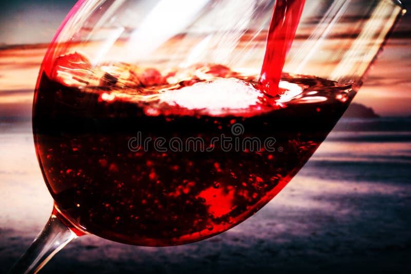 Glass of full bodied red wine being poured stock image