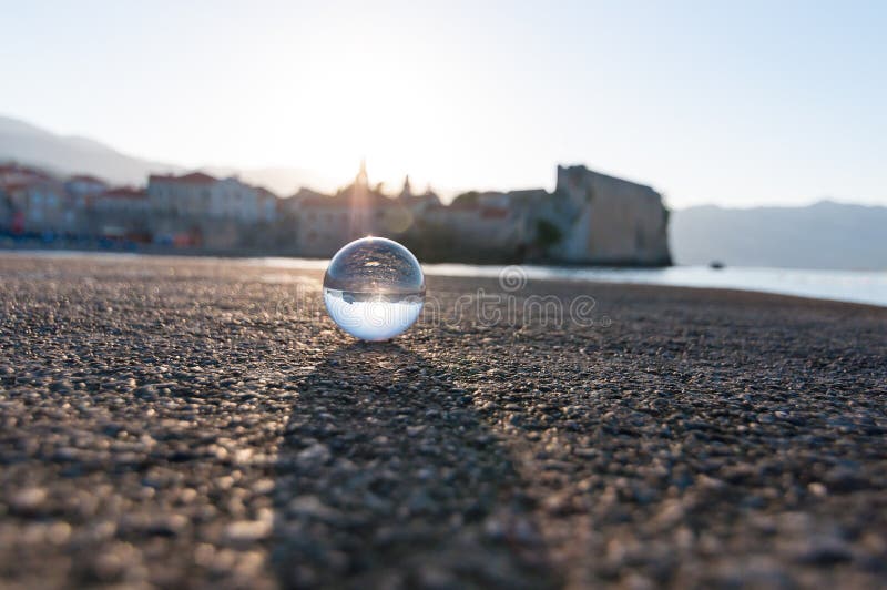 Glass genomskinlig boll på havsbakgrund och royaltyfri fotografi