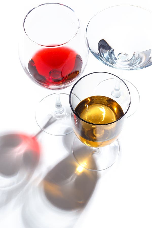 Glass glasses with drinks of different colors on a white background. Top view. The concept of an alcoholic cocktail